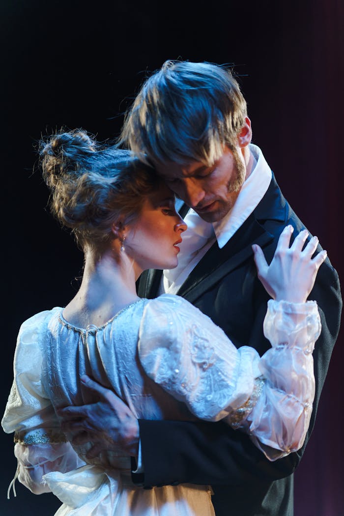 Romantic theatrical moment with actors embracing onstage.